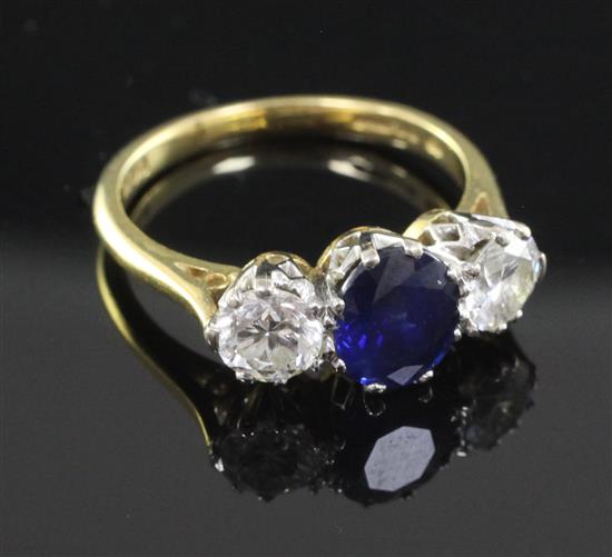 A 1980s 18ct gold three stone sapphire and diamond ring, size L.